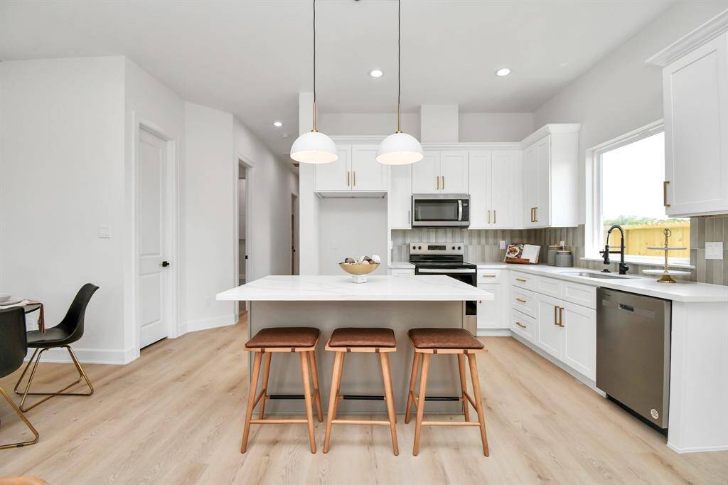 This kitchen is designed for both functionality and style, featuring an island that comfortably seats 2-3 guests. The island also provides ample workspace, making it perfect for meal prep and casual dining.