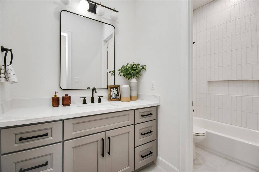 Each secondary bedroom is complemented by a full-sized bath featuring floor-to-ceiling tile in the shower and tub area. This luxurious design enhances the space with a sleek, modern look and provides a touch of sophistication and durability.