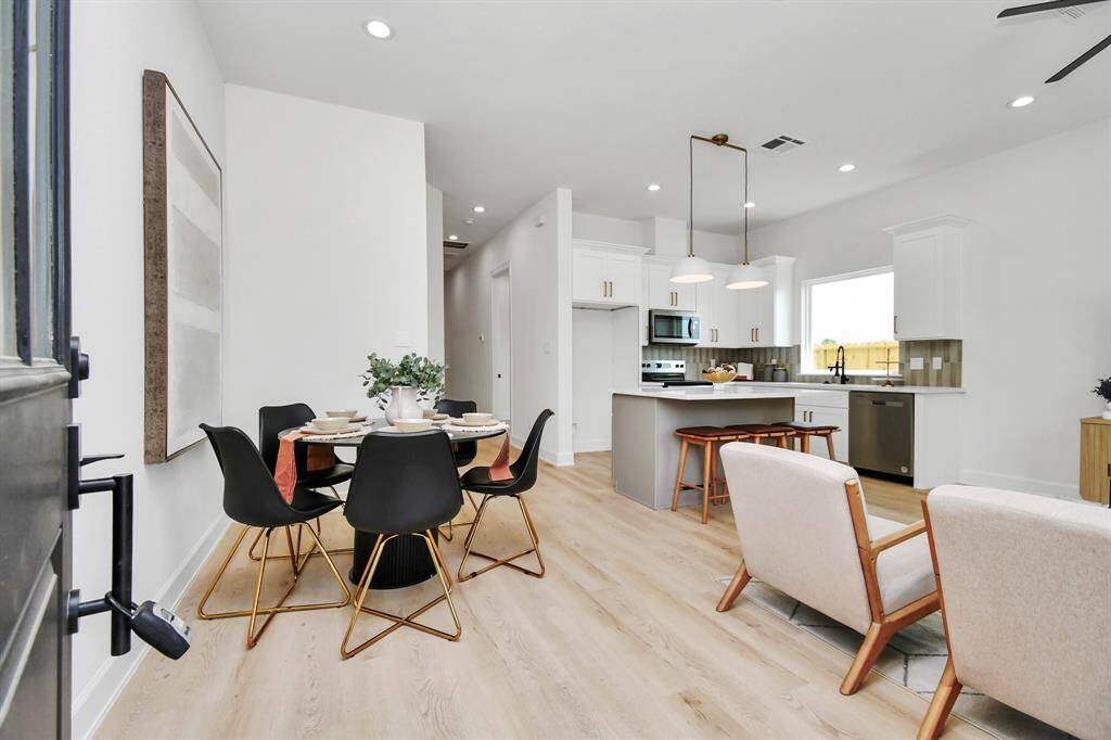 As you enter, the dining area greets you with a view of the kitchen, creating a welcoming focal point that seamlessly blends with the open layout and flow of the home.