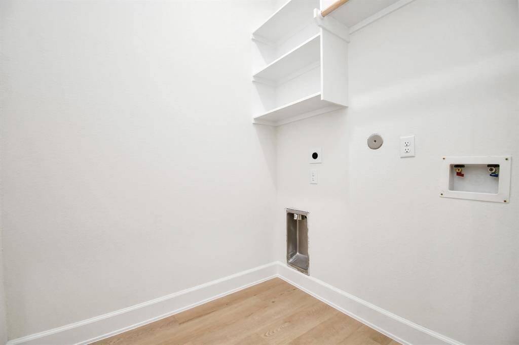 The utility room comes equipped with built-in storage shelves, offering convenient space for organizing laundry essentials and keeping everything neatly in place. This thoughtful feature adds practicality and efficiency to your daily chores.
