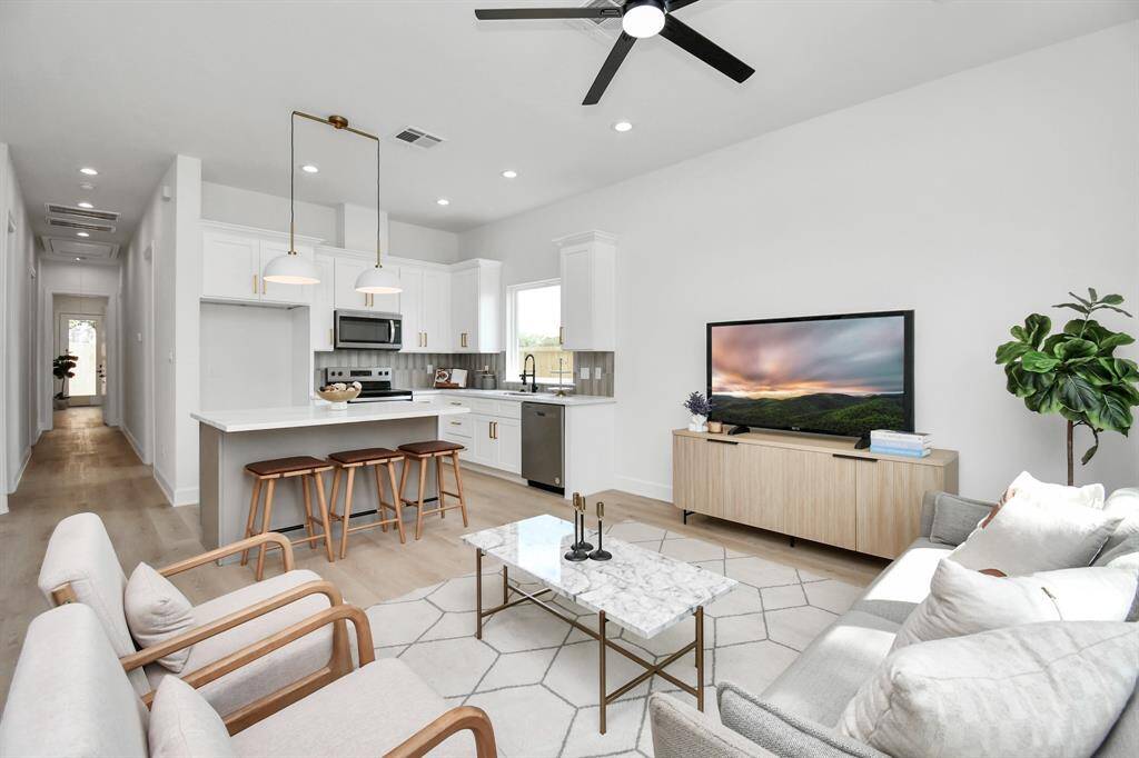 The expansive living room area is perfect for hosting gatherings or relaxing, offering plenty of space for both entertaining and lounging.