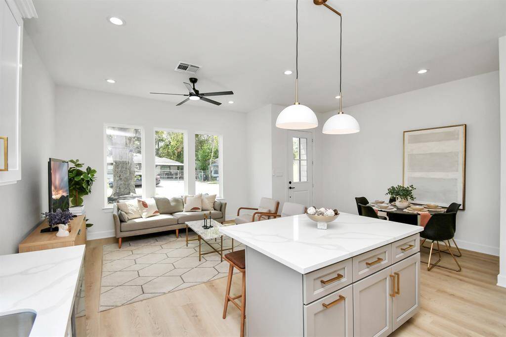 The kitchen showcases stunning two-tone cabinetry, with a sleek gray accent island that contrasts beautifully against the crisp white cabinets. This elegant combination not only adds visual interest but also creates a sophisticated, modern look.