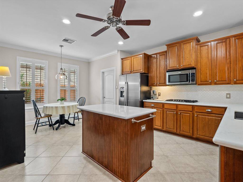 Updated kitchen featuring quartz countertops, tile flooring, and ample cabinet space.