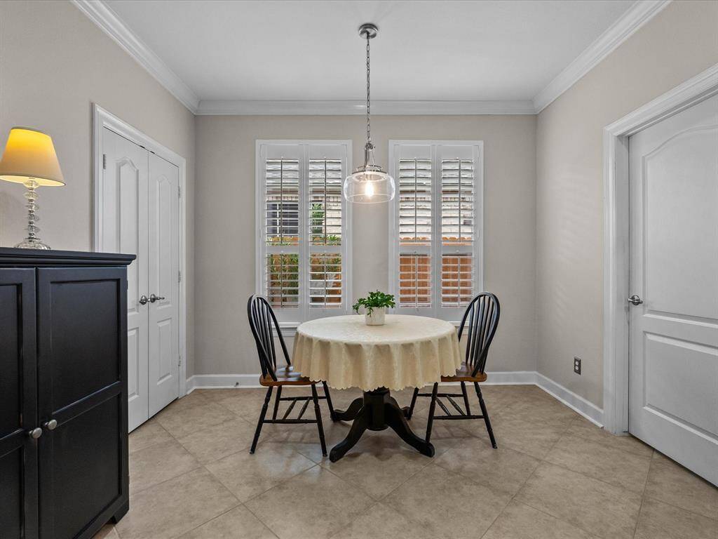Cozy, yet spacious breakfast nook featuring tile flooring and plantation shutters. This bright space offers a charming spot for casual dining, with ample natural light and easy access to the kitchen. Large pantry!