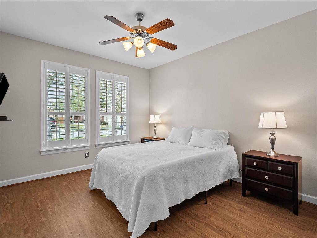 Comfortable guest bedroom or flex space with LVP flooring and plantation shutters. This room offers ample natural light and a versatile layout to suit various needs.