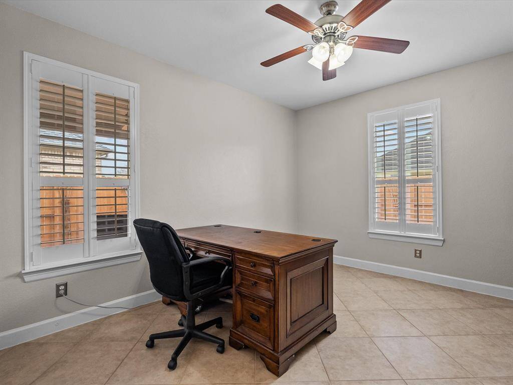 Versatile flex space, ideal for a home office or guest room, featuring tile flooring and plantation shutters