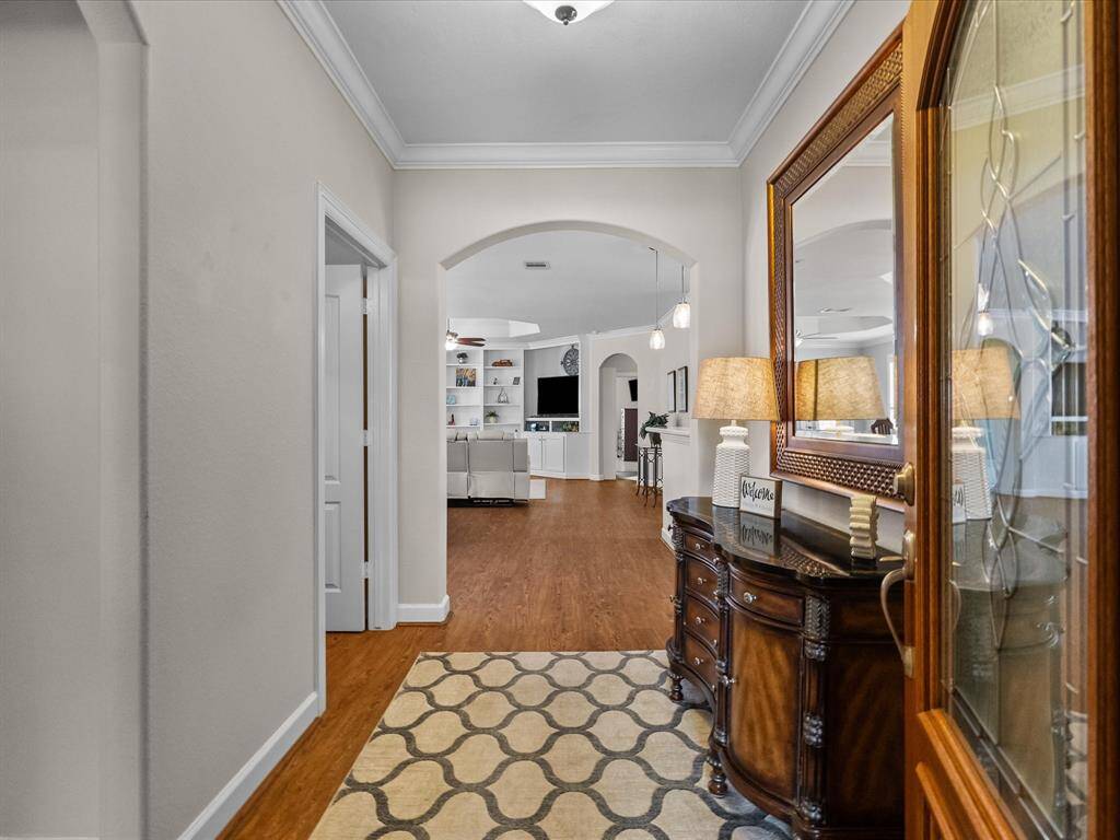Inviting entryway featuring LVP flooring and an arched doorway leading to the main living area. Notice the elegant trim work and ample natural light.