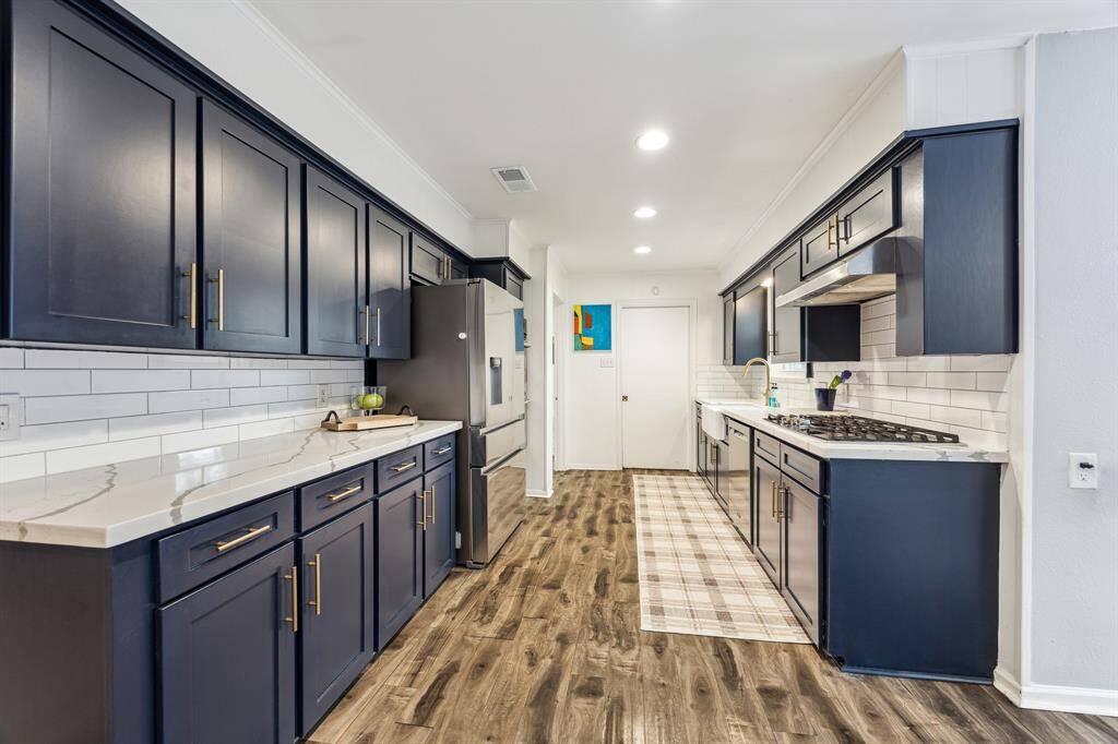 The kitchen features gorgeous cabinetry, stainless steel appliances- a recently new dishwasher and gas range. Recent white subway tile backsplash and marble countertops provide a clean, elegant look.