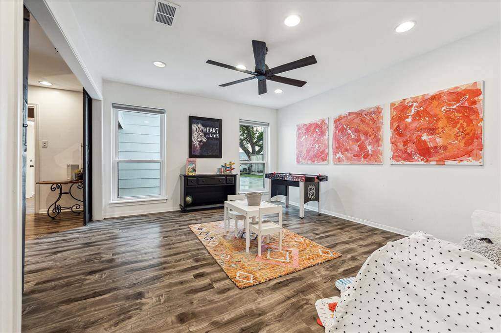The office/playroom features a great space with a ceiling fan, and ample natural light from large windows. Perfect for a family-friendly space or a creative retreat.
