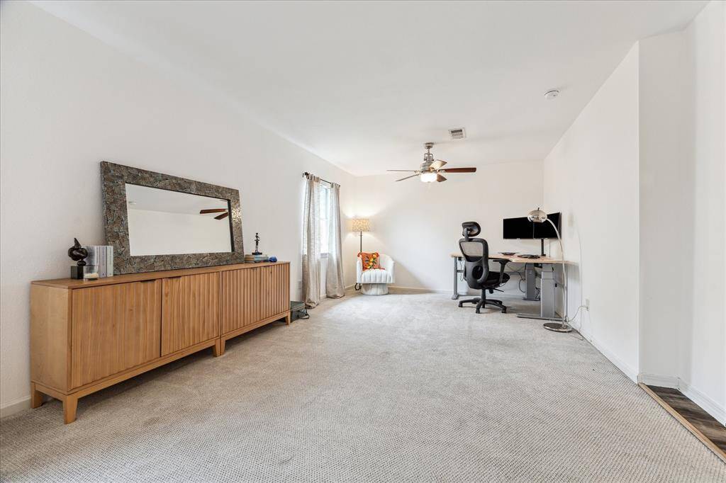 This spacious secondary bedroom features neutral carpet, a ceiling fan, and ample natural light. It has a large closet and two windows, it could be kept as one oversized bedroom or could easily be split into two bedrooms if there is a need for a five bedroom house as well.