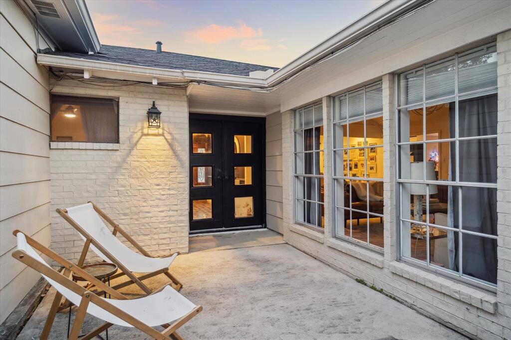 Off the Living Room is a cozy patio area with large windows and a modern door.