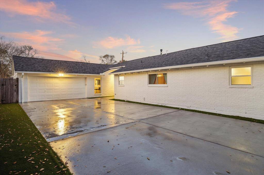 This home offers a spacious, recent driveway leading to a two-car garage. The exterior features white brick with a modern look and a neatly trimmed lawn. The lighting is warm and inviting. This home features such a functional floorplan perfect for entertaining and with room for all.