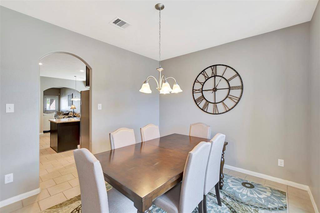 The room has neutral walls and arched doorways that lead to an open kitchen and living space, creating a seamless flow throughout the home.