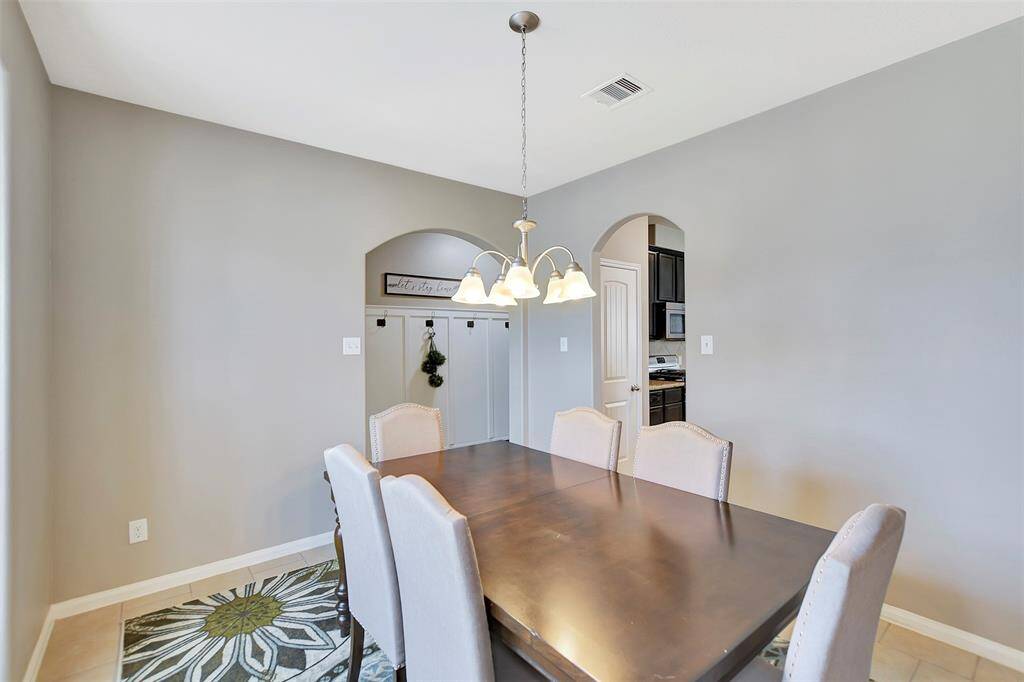 This dining room features a modern, neutral color palette and tile flooring.