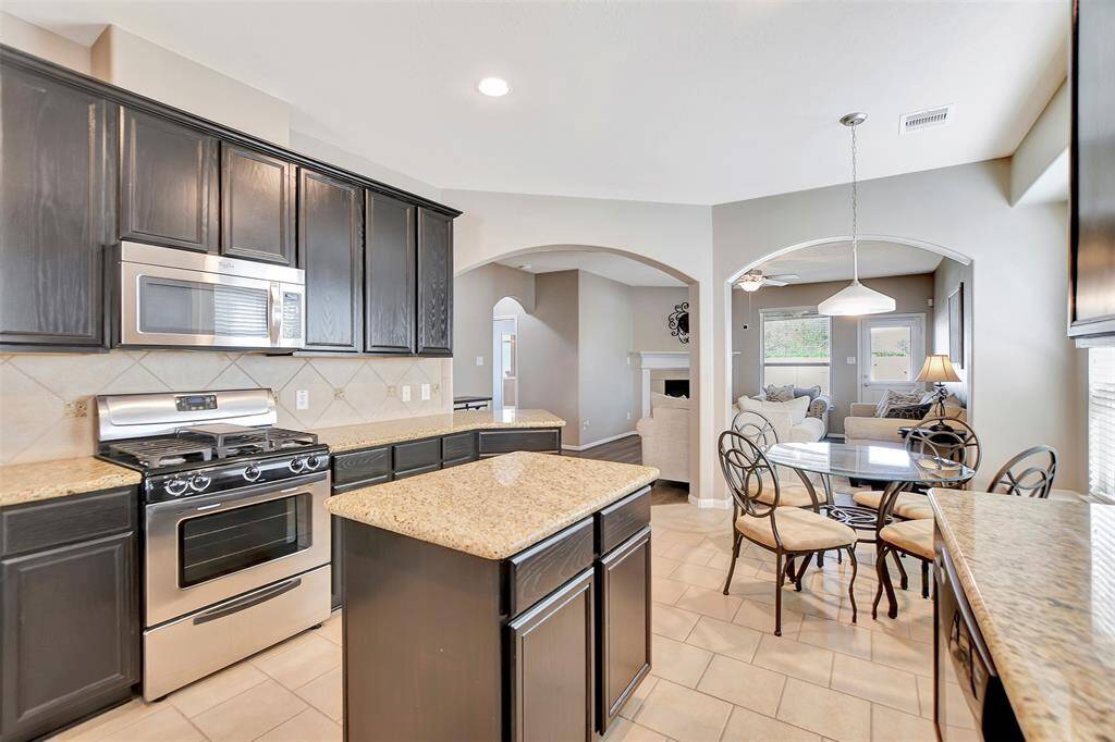 The open layout leads to a dining area and a bright living room with large windows.