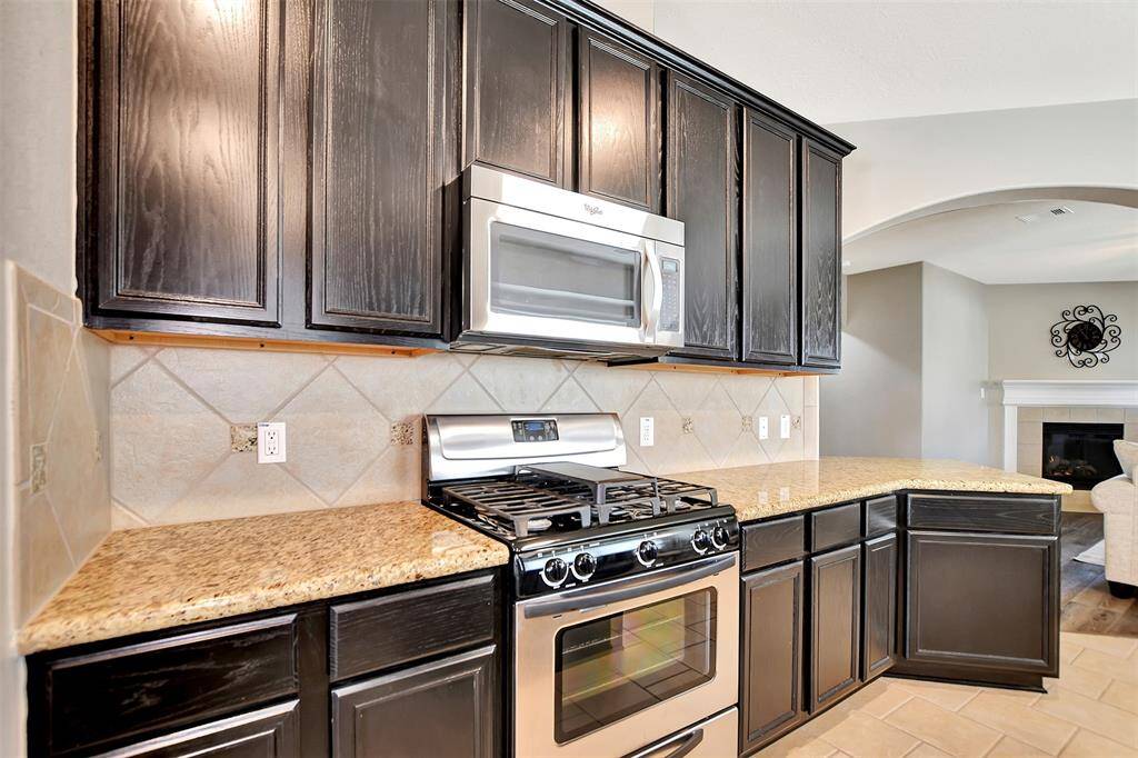 This kitchen features a gas stove and microwave.