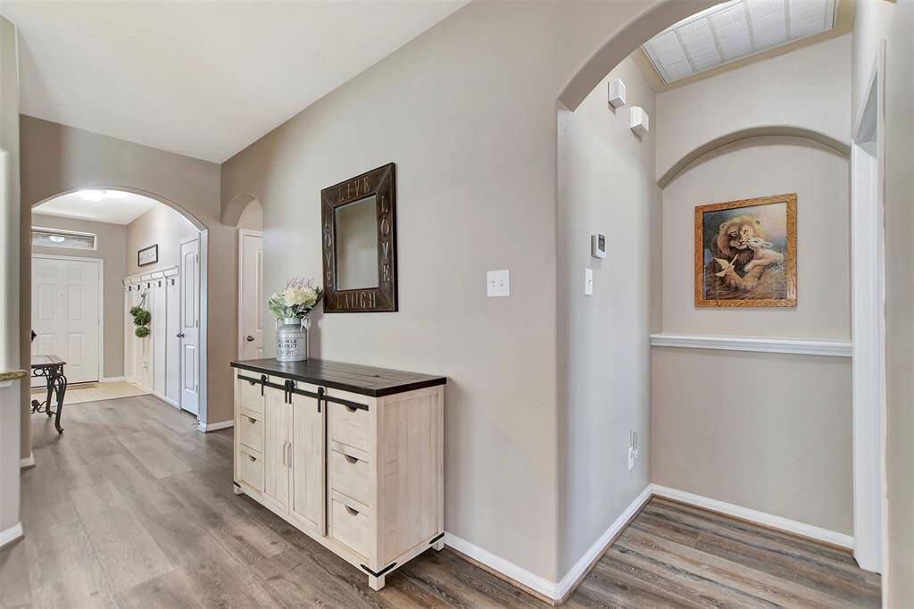 This photo showcases the arched doorways, and a hallway nook with artwork.