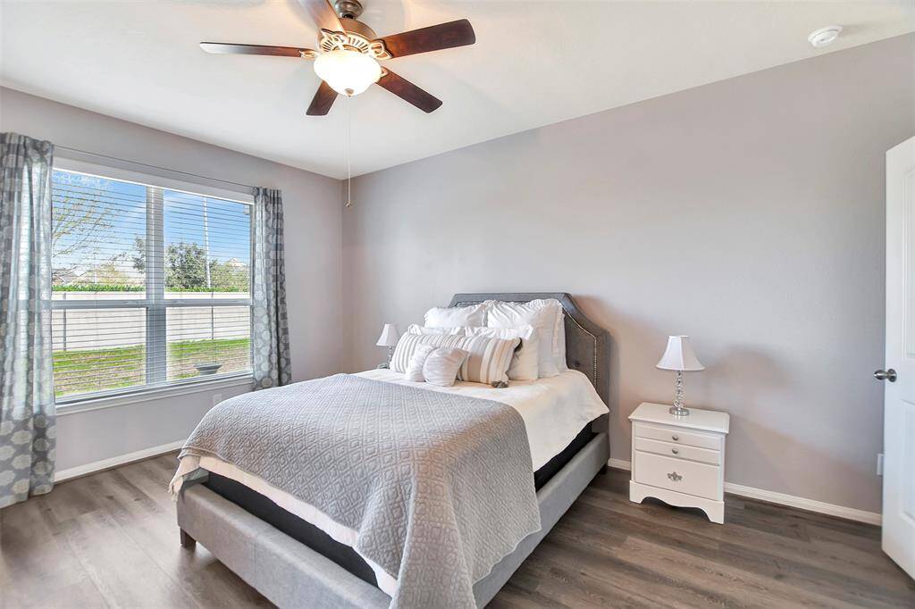 This bright bedroom features a large window with curtains, allowing natural light to illuminate the space.