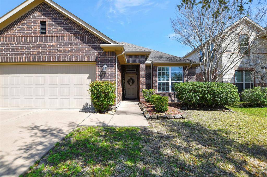 The home features a brick exterior with a welcoming front entrance. The neatly landscaped yard includes a walkway,