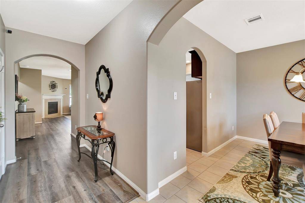 The entryway features arched doorways leading to the dining area & living room.