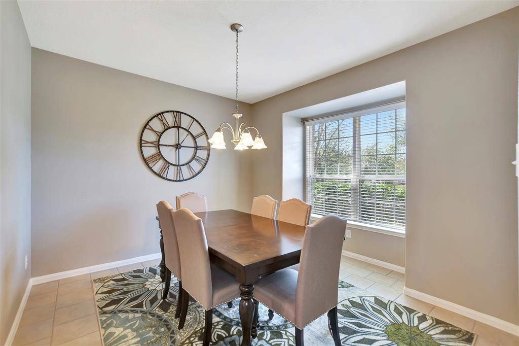 Bright dining area with neutral walls and a large window that allows natural light.