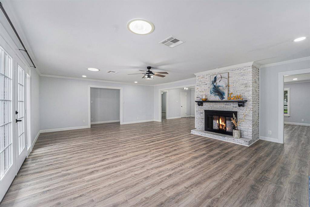 Central brick fireplace, and ample natural light from large French doors. Ideal for cozy gatherings and modern living.