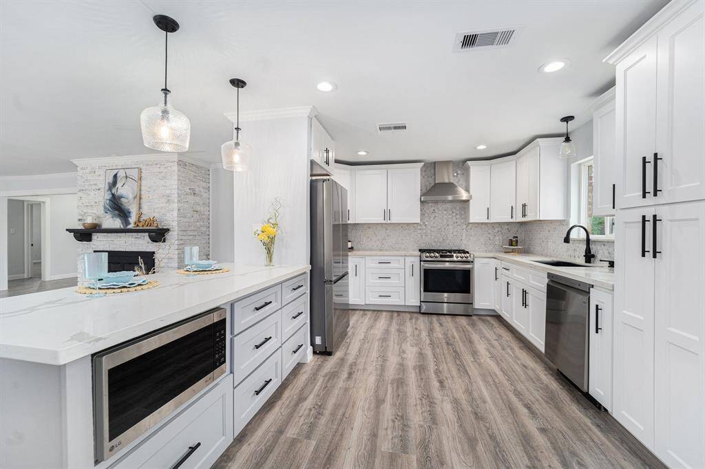 This dove-tone cabinet island gives great accent in the kitchen with an under-mount microwave and large drawers.