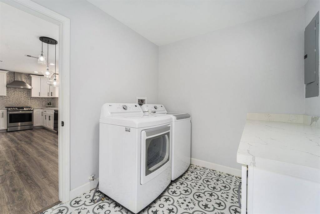 Utility room off the kitchen has quartz counter top and caninet with four extra large drawers, and leads out to the garage.