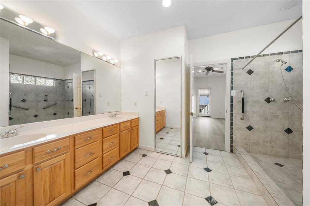 Welcome to the primary guest bathroom - featuring classic, timeless finishes that offer charm and character. This spacious bathroom features a large double vanity with ample storage, a walk-in shower, and a full mirror for outfit checks on the way out!