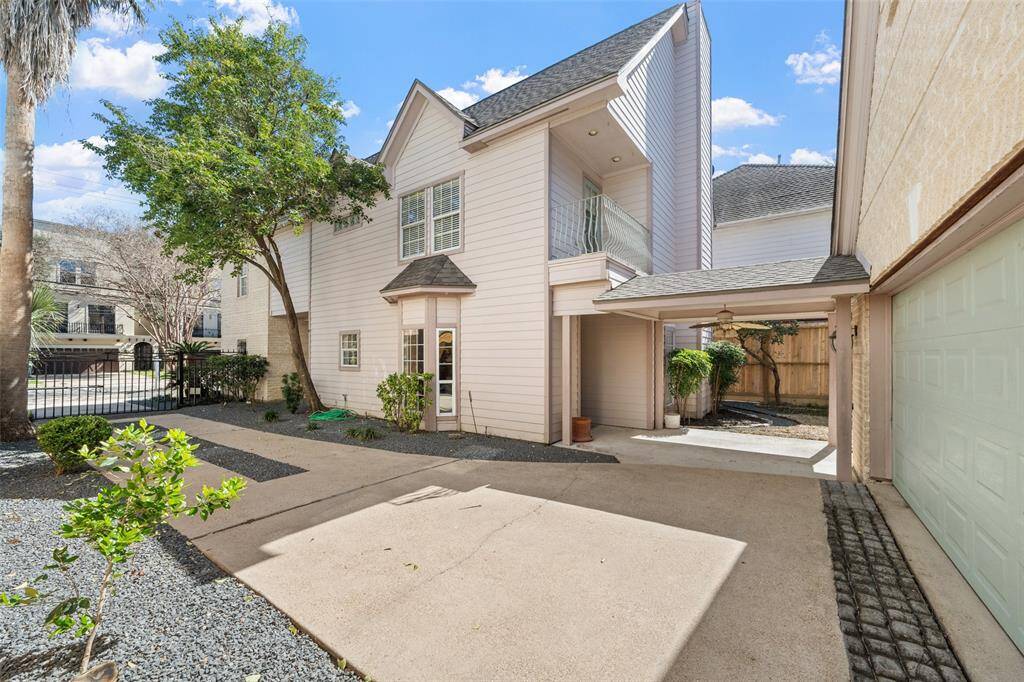Vast driveway leading to a detached garage, offering plenty of space and a cozy, private outdoor retreat perfect for relaxation.