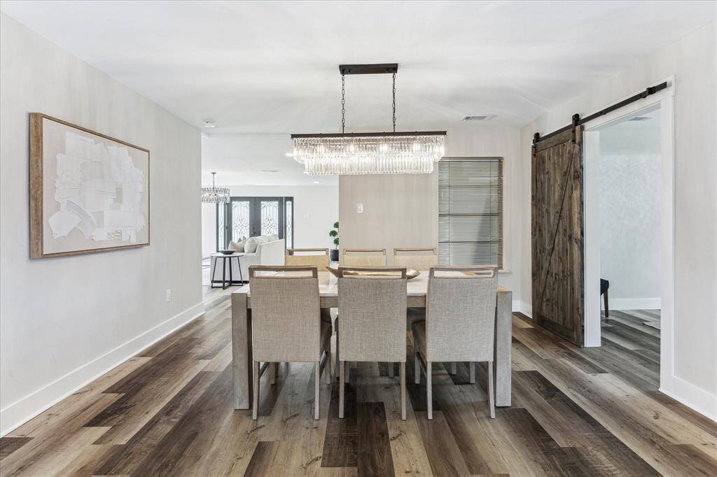 Gather them around your table to honor old traditions and create the new in this inviting dining area. Featuring a chic chandelier, LVP flooring, and neutral paint, this space provides the perfect backdrop for every occasion from elegant dinner parties to casual family get togethers.