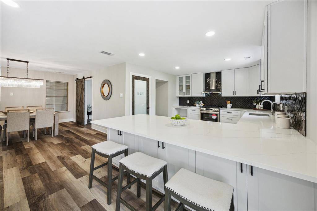 This open floor plan offers the perfect blend of casual and formal dining, featuring a spacious island with bar seating and an elegant formal dining room nearby. Whether hosting lively gatherings or enjoying quiet meals, this thoughtfully designed space provides functionality, style, and seamless flow for everyday living.