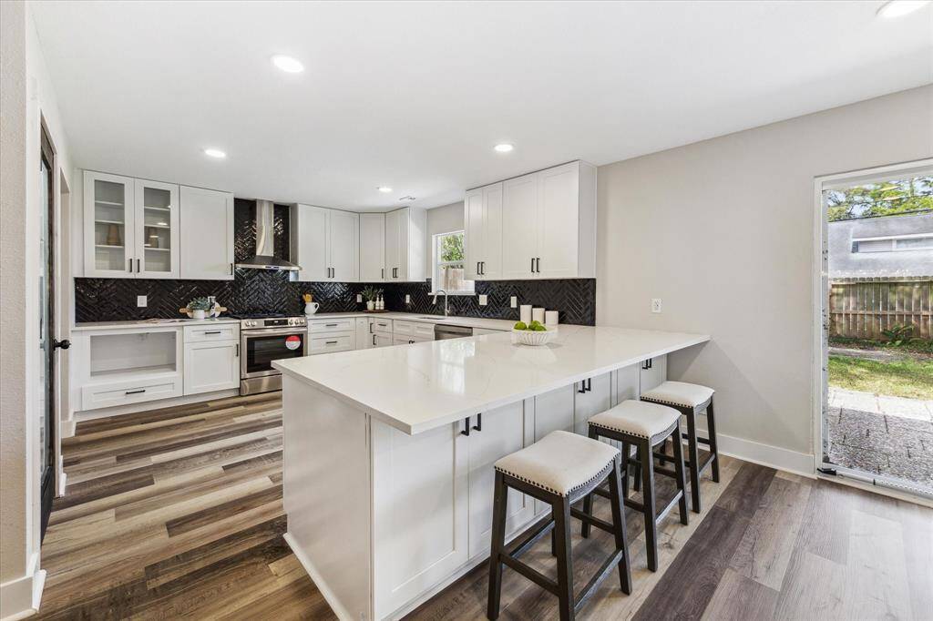 This completely updated kitchen is a chef’s dream, featuring Quartz countertops, designer tile backsplash, and sleek stainless steel appliances. The spacious island with bar seating provides the perfect spot for casual dining and entertaining. A large walk-in pantry ensures ample storage, making this kitchen as functional as it is stylish.