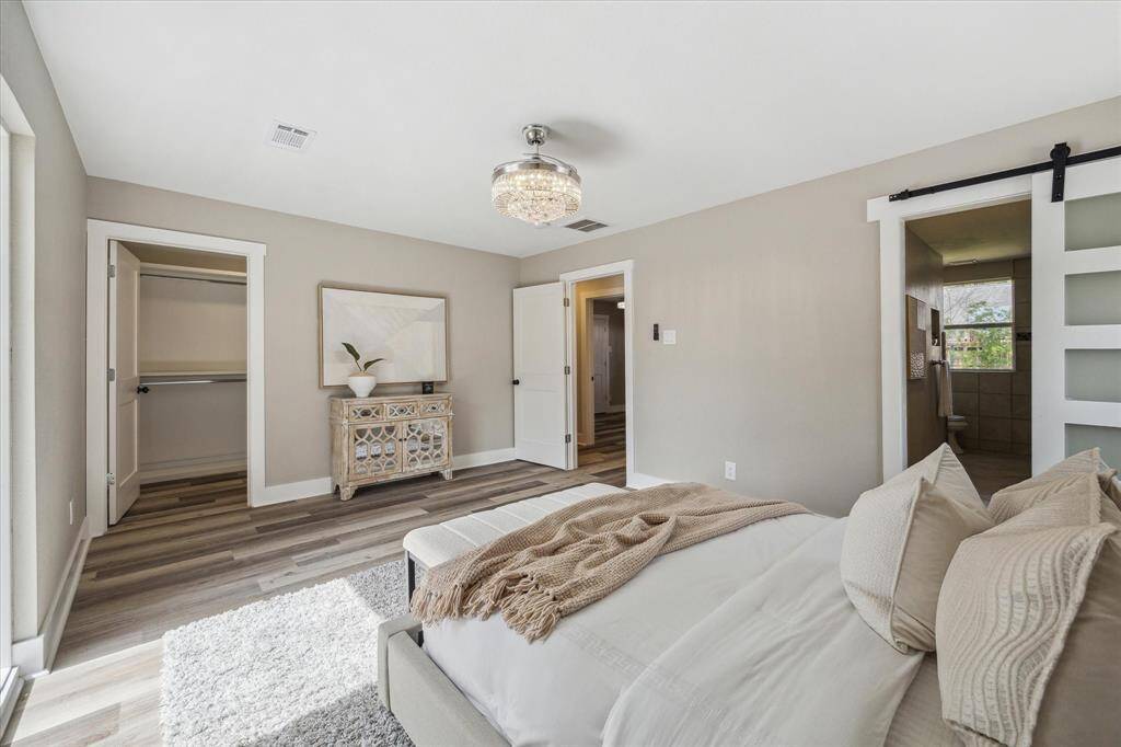 This spacious owner’s suite blends style and functionality, featuring a large custom walk-in closet and a luxurious ensuite tucked behind a modern sliding barn door. Thoughtfully designed for comfort and convenience, this private retreat offers the perfect place to unwind and recharge in style.