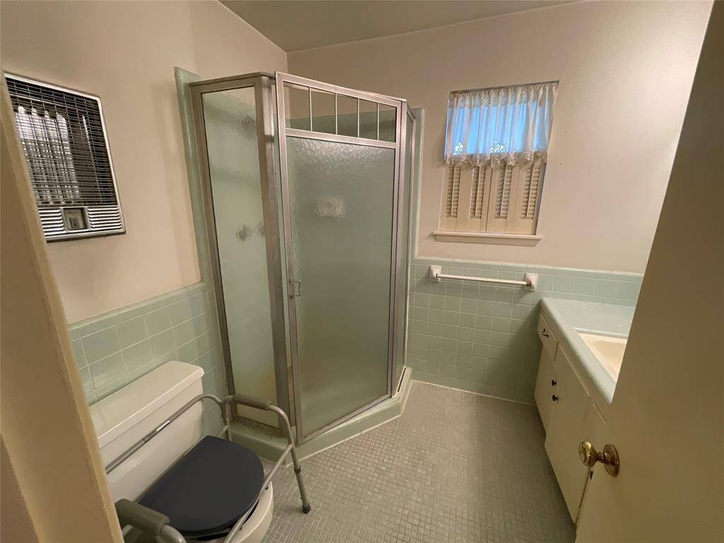 Primary bathroom with corner shower is efficient for getting ready in the morning