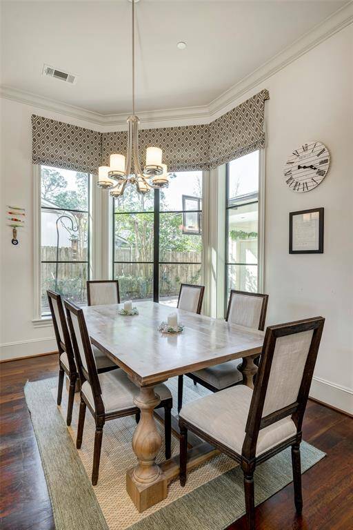 Close up of breakfast area with angled windows overlooking landscaped driveway. Natural lighting is abundant.
