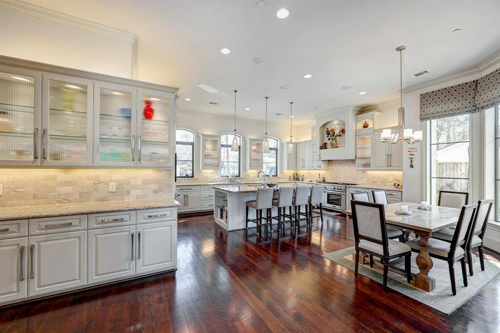 Butlers pantry has lighted glass cabinets and under the cabinet lighting. 3  beautiful pinnacle lights with vintage like glass. There is so much storage that the drawers are almost empty. You can see the recipe books on the shelves at the end of the island. Little details add so much.