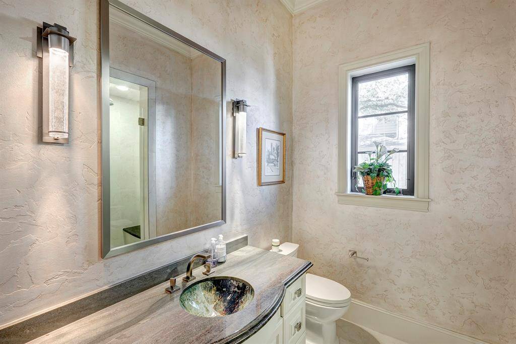 Beautiful full bath serves as powder room and has a frameless shower. The abstract colored glass sink is a WoW factor. The downstairs bedroom uses this bathroom.