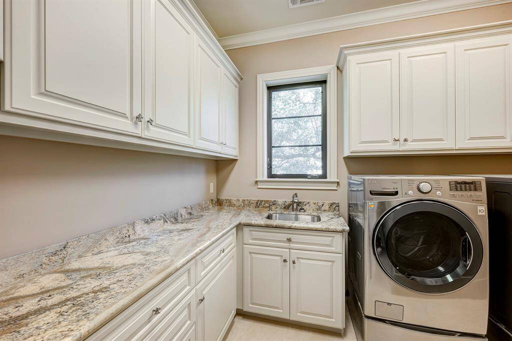 Generous laundry room up has a sink and yes there's a dryerin  here too! There's a hanging rod by the door. A window really is a luxury in the laundry room. Plenty of room in here to store craft items. Floored attic near here;access pull (stick w hook)in nearby closet
