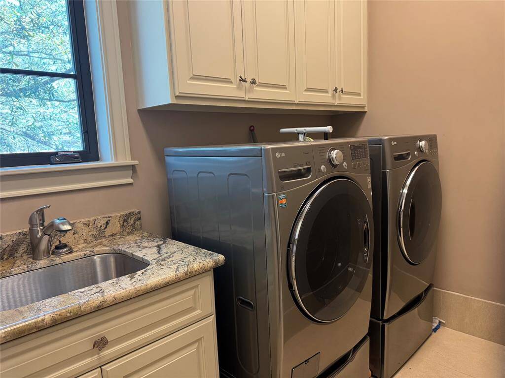 Yes washer and dryer stay! Close up of large soaking sink. The ironing board can stay. It is wedged between the washer and dryer.