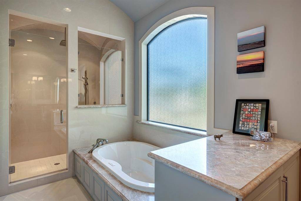 Curved window by spa tub and frameless shower