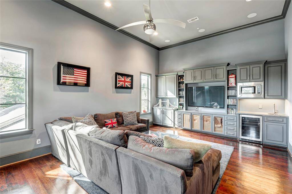 Game room towards TV and built ins. Speakers in ceiling. Cabinetry storage for games and shelves for trophies. Buyer can replace speaker fabric.