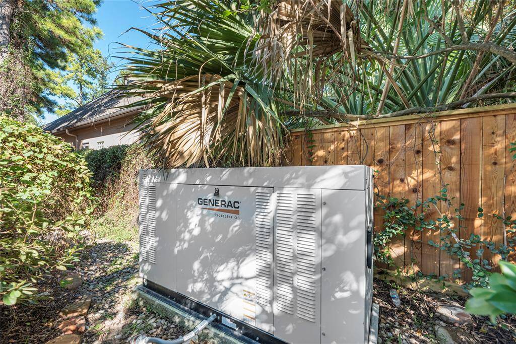 This photo shows a Generac backup generator installed in a landscaped backyard area, offering reliable power security for the home.