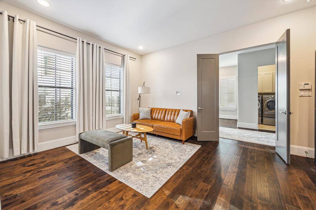 Flexible sitting area in the primary suite is perfect for lounging, reading, or enjoying morning coffee. French doors lead to a connecting hallway with access to laundry and additional rooms.