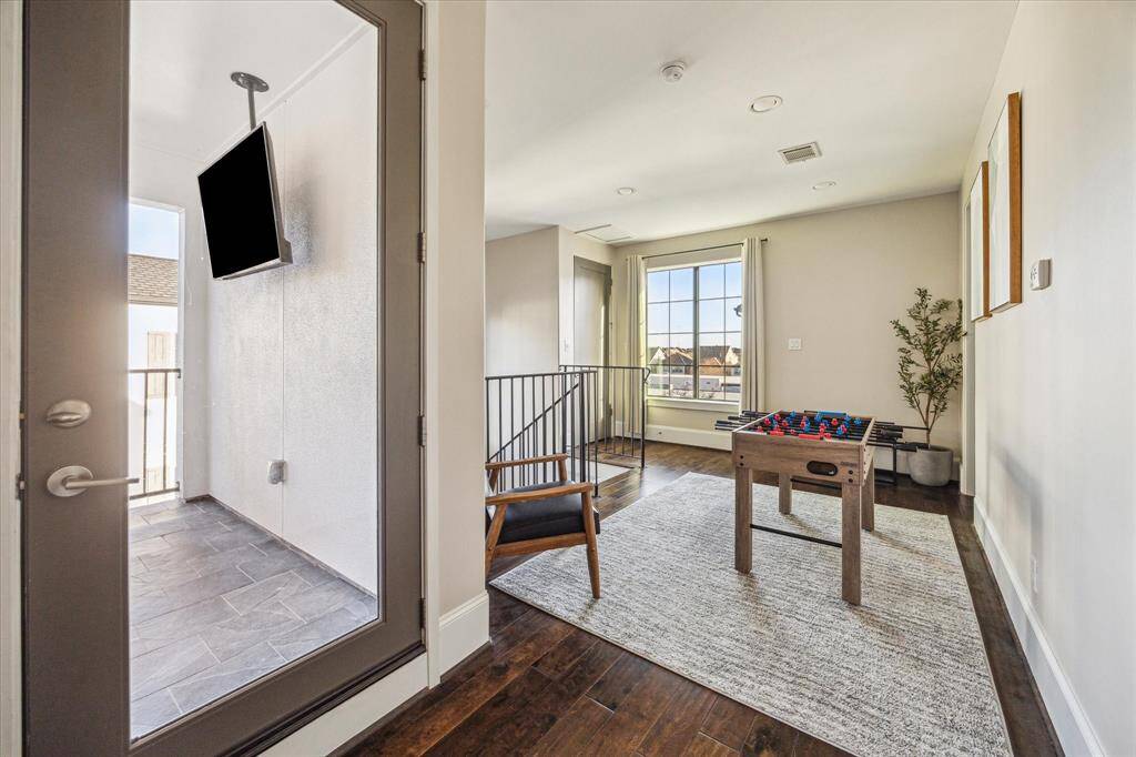 Step out from the game area to a private balcony with tile flooring and a mounted TV — an ideal spot for enjoying morning coffee or evening sunsets.