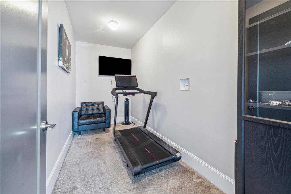 A dedicated fitness room offers privacy for workouts, with a mounted TV and space for your favorite equipment.