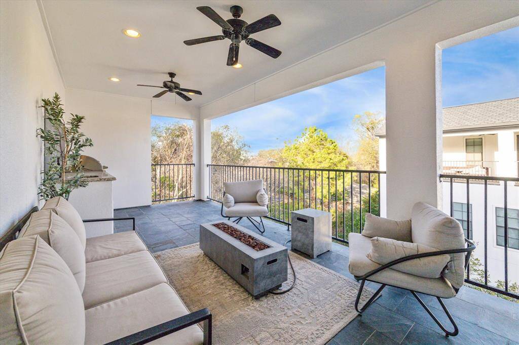 Enjoy outdoor living at its best on the expansive covered terrace, featuring dual ceiling fans, a fire pit, and room for lounging or entertaining.