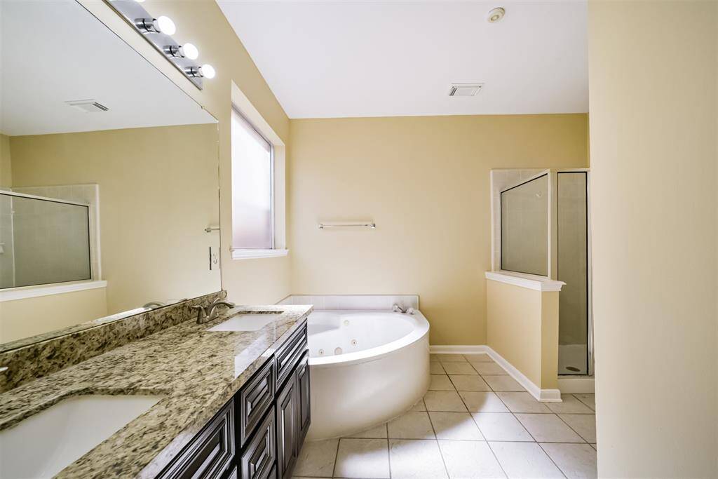 The primary bedroom's ensuite bathroom, complete with a jacuzzi tub, walk in shower and frosted window for ultimate privacy!