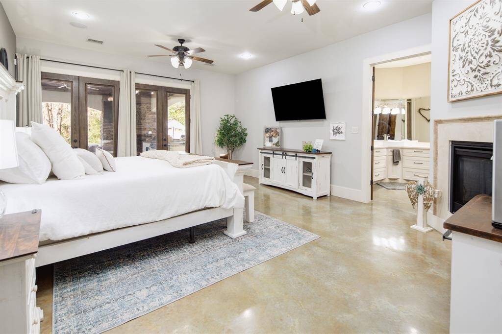 Entering the primary suite you'll immediately notice the high ceilings & double sided fireplace. Easily access the covered patio from the double French doors, & enjoy your morning coffee overlooking the pool.