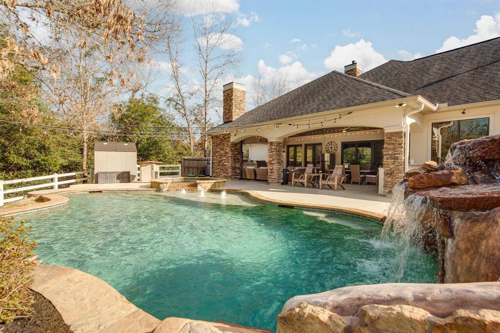A hosting paradise complete with sparkling pool, hot tub, grotto/slide, outdoor kitchen & covered patio.